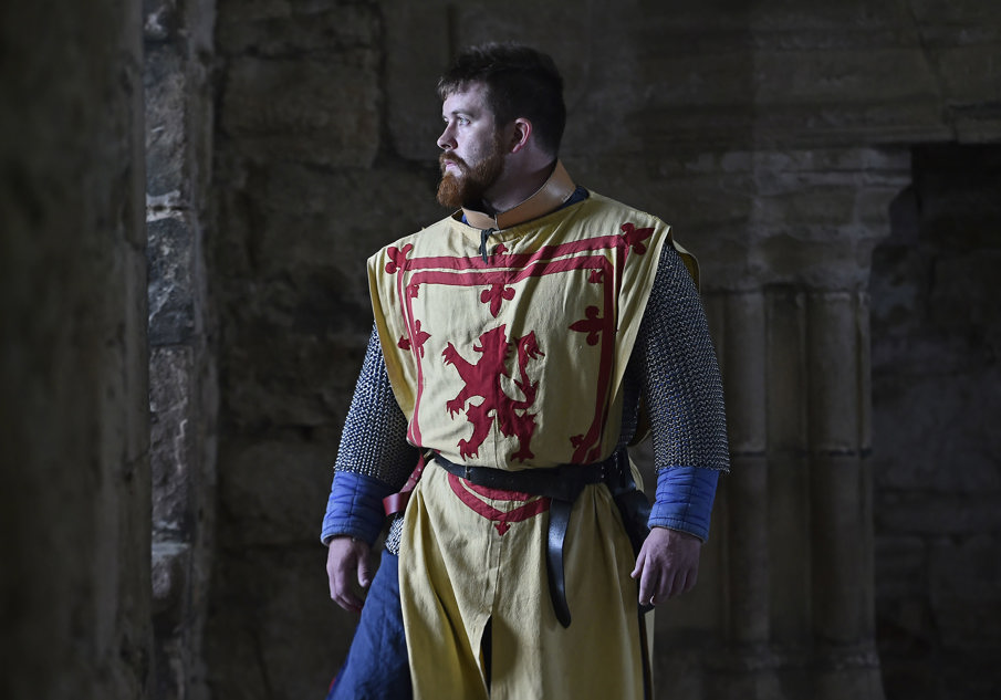 A man in chainmail and a Lion Rampant tabard