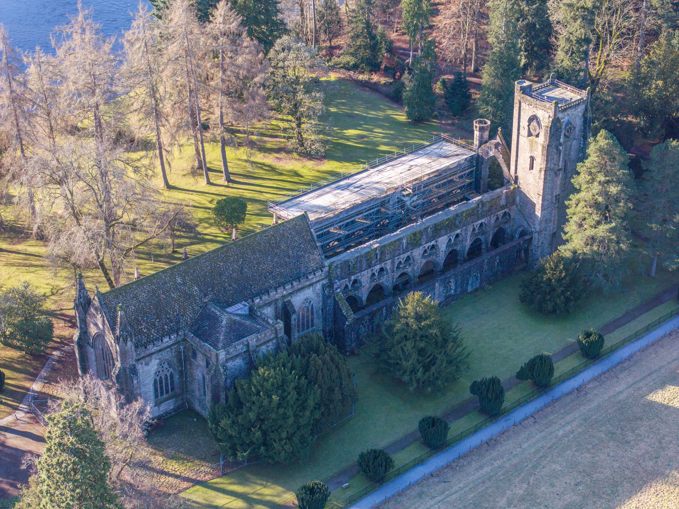 An aerial view of a large historic cathedral surrounded by pretty woodland.