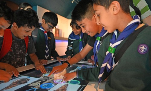 A group of scouts having fun round an interactive table