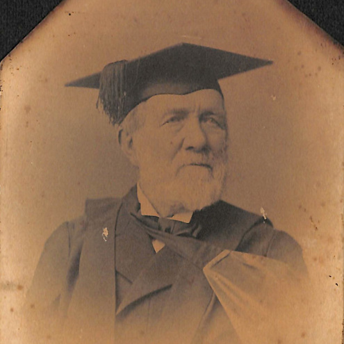 Old portrait image of David Robertson. He has a white beard and is wearing an academic cap and gown.