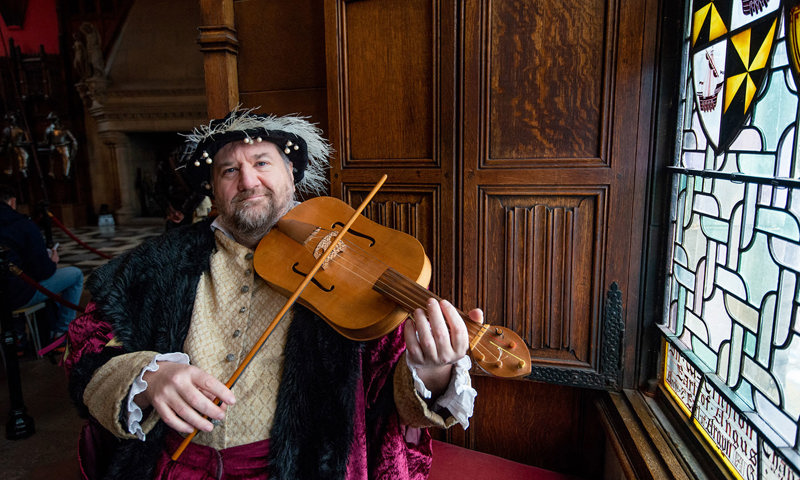 A person in period costume playing a violin