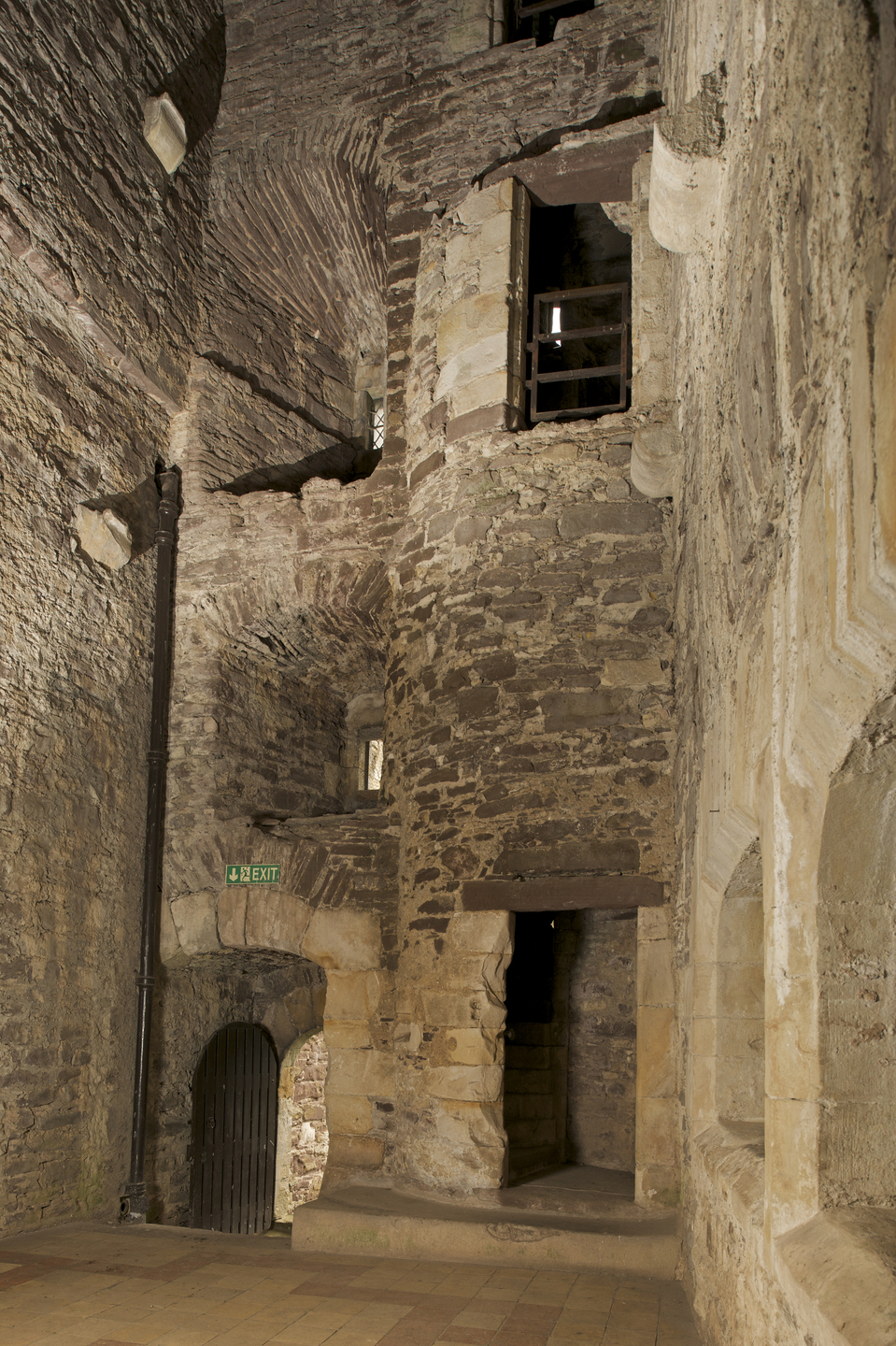 Interior of a historical stone building in good condition. The building is tall, and you can see a couple of passages at different levels. 