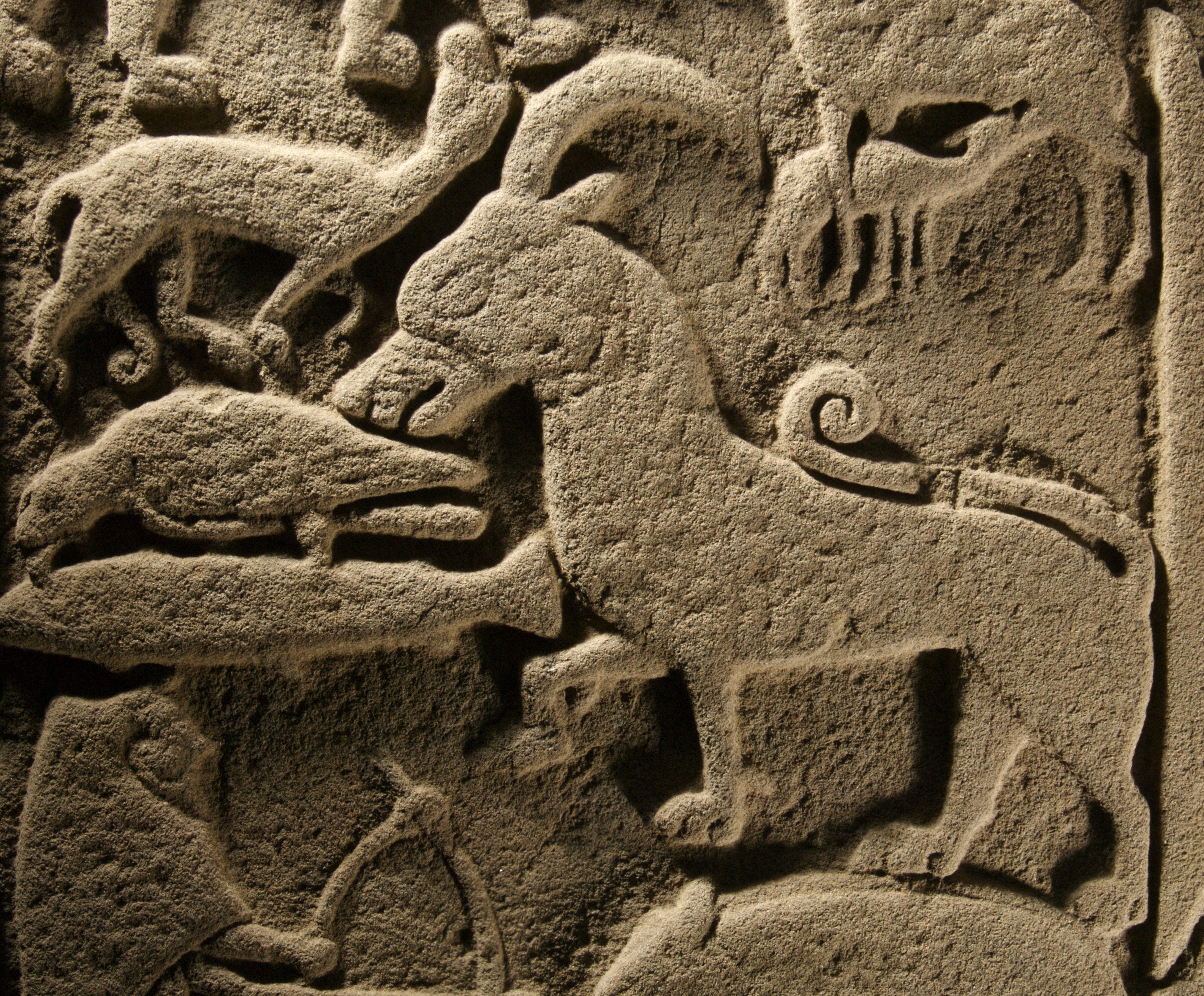 Detail of carved stone showing a number of creatures including a horned mammal, a bird and a fish