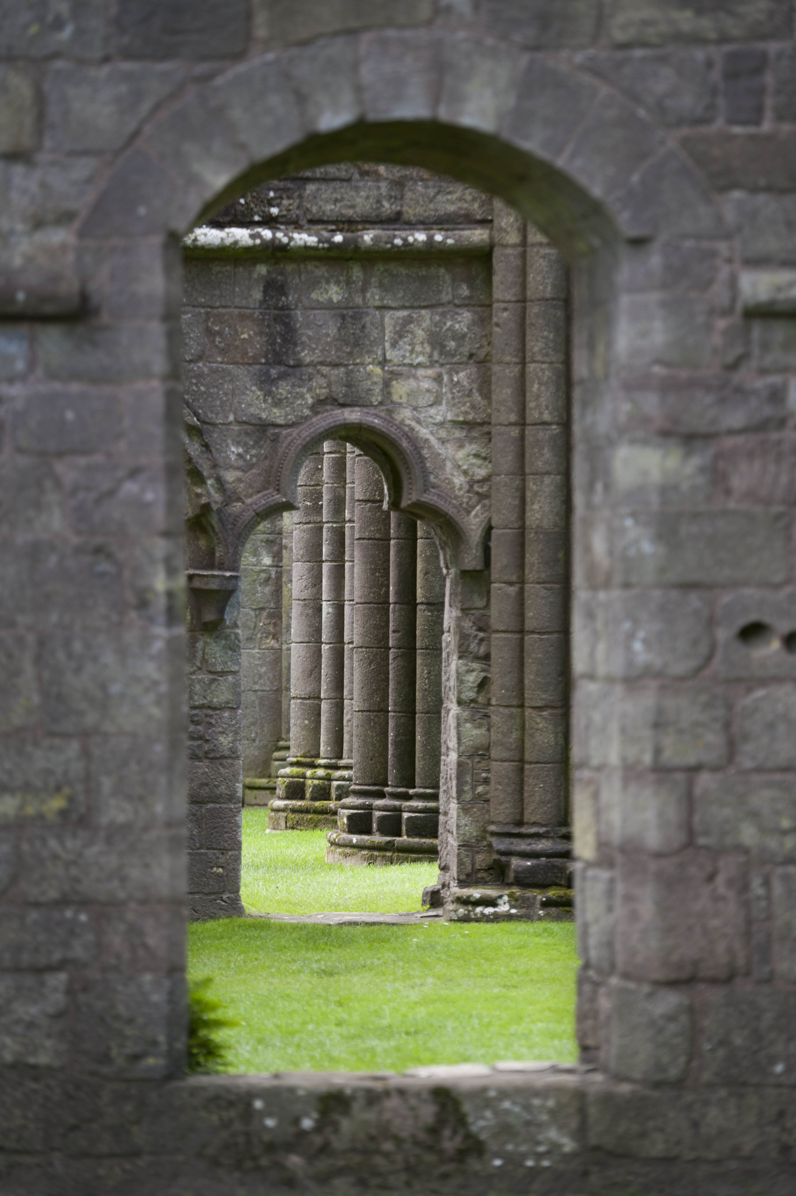 A stone window opening looking onto a stone decorative archway