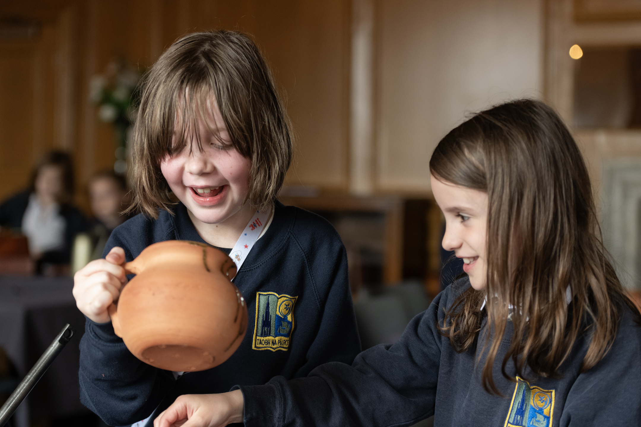 Two school children looking at a replica chamber pot