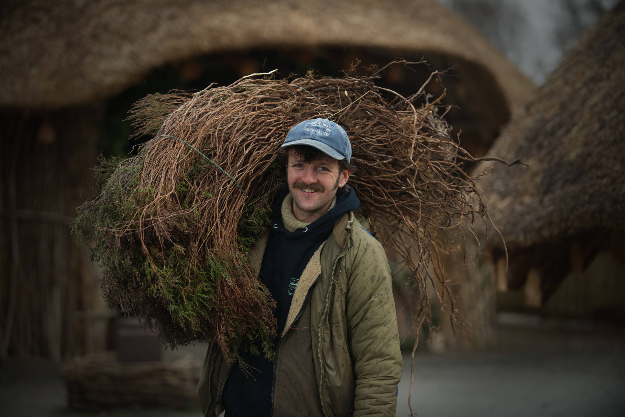 Man carrying thatching materials