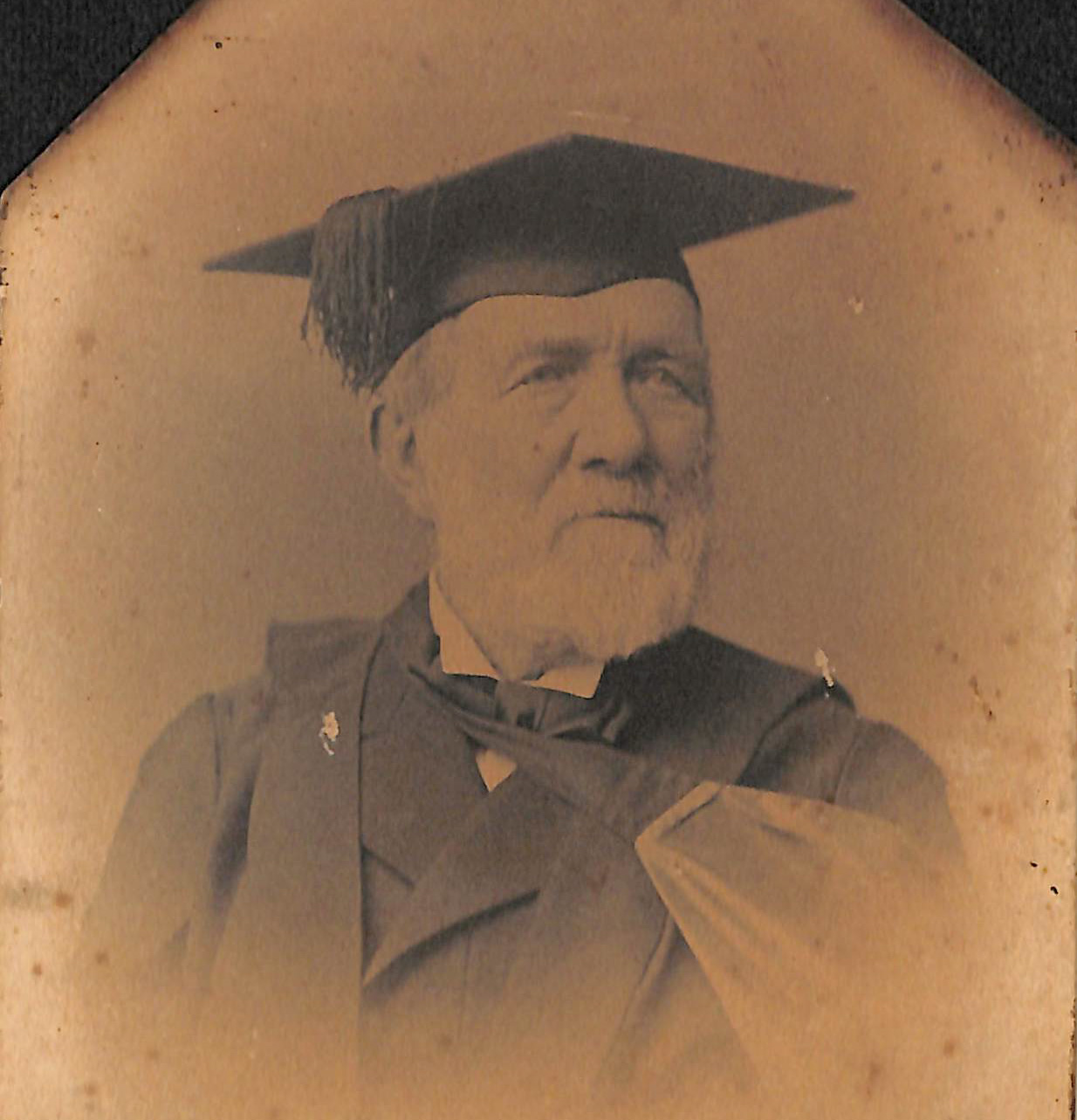 Old portrait image of David Robertson. He has a white beard and is wearing an academic cap and gown.