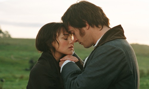 A still from the Pride and Prejudice film showing Mr Darcy and Elizabeth Bennet as they embrace. They stand in a green field and the sun shines behind them.