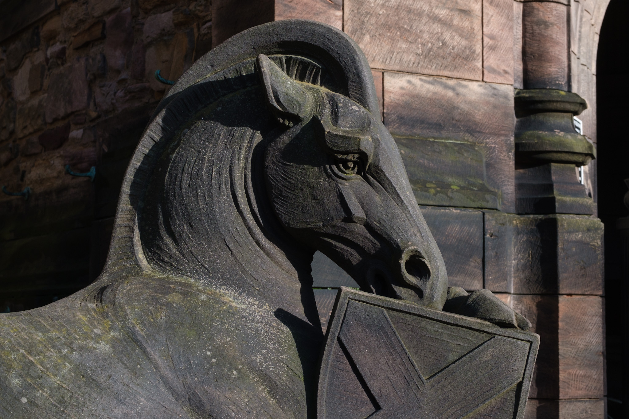 An intricately carved stone horse, black in colour.
