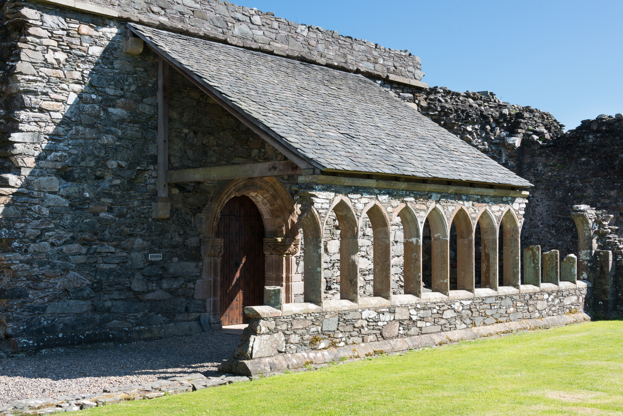 Pillared section of abbey with sloped roof - an outdoor covered walkway.