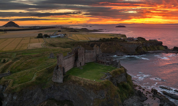 Aerial view of Tantallon Castle, with its distinctive red sandstone curtain wall, and a beautiful late summer sunset 