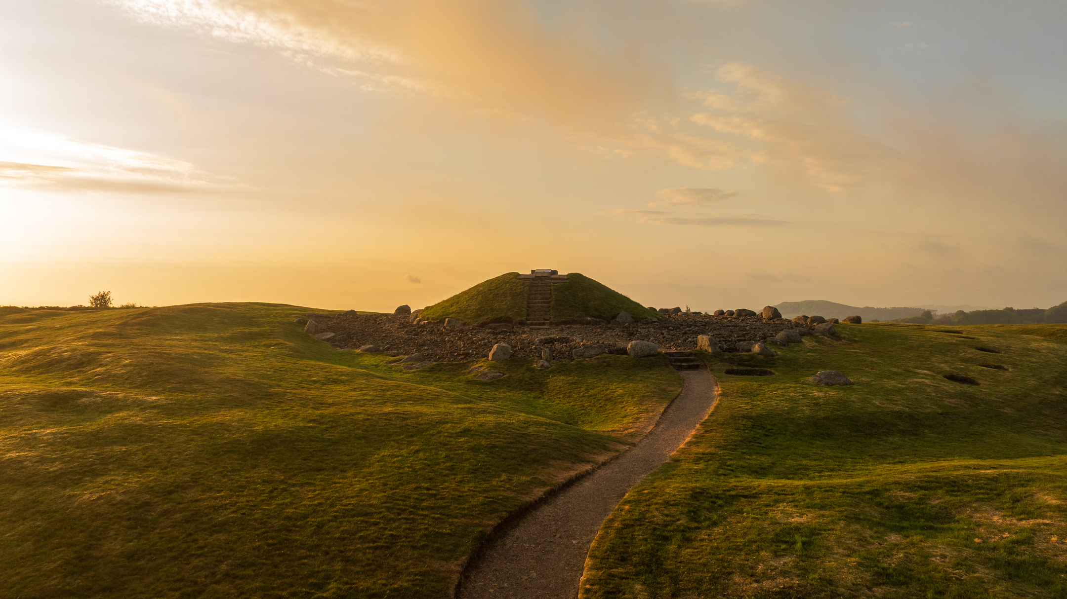 Small hill  or mound with path leading up to it, with golden sky
