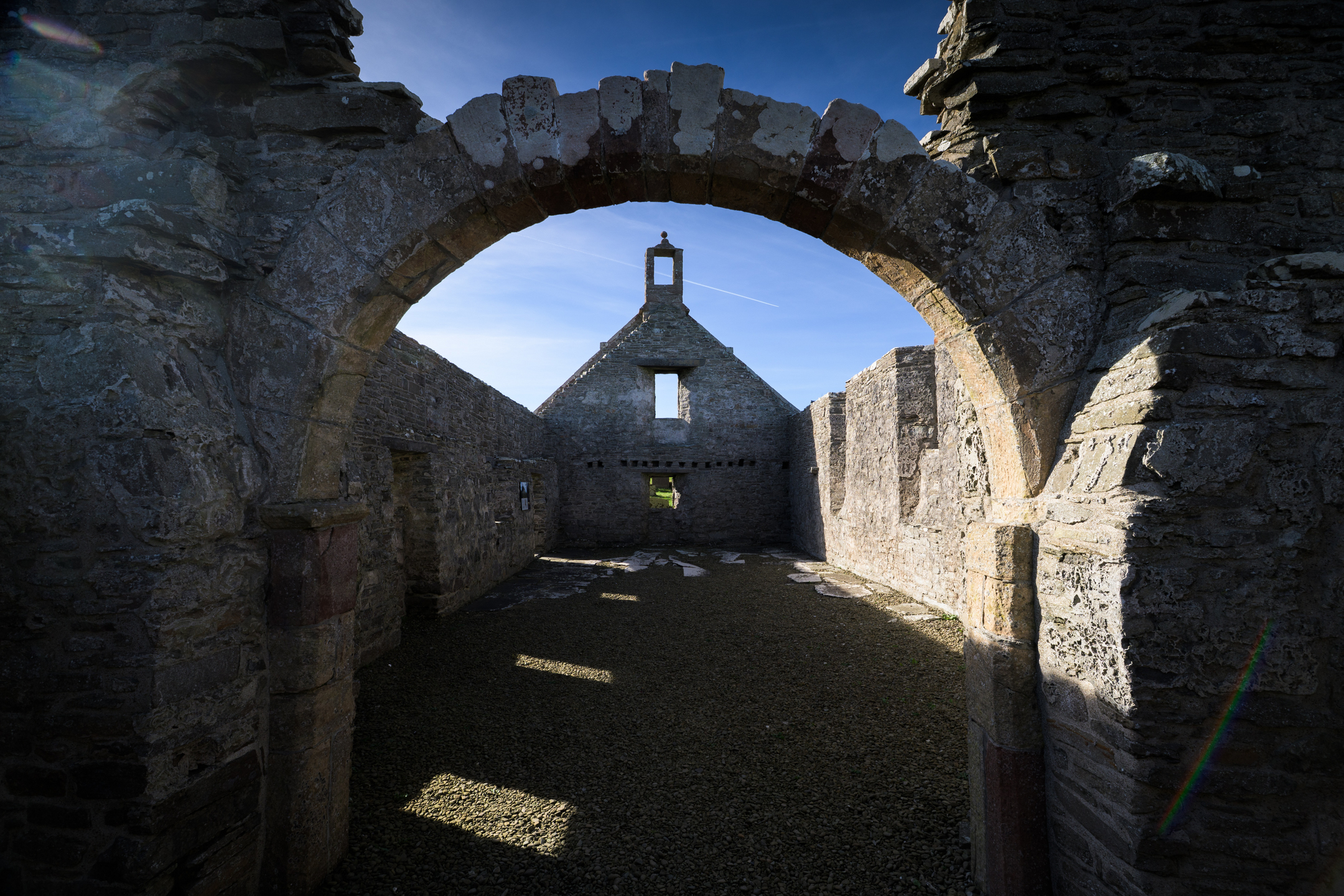 church remains without roof, interior view through archway