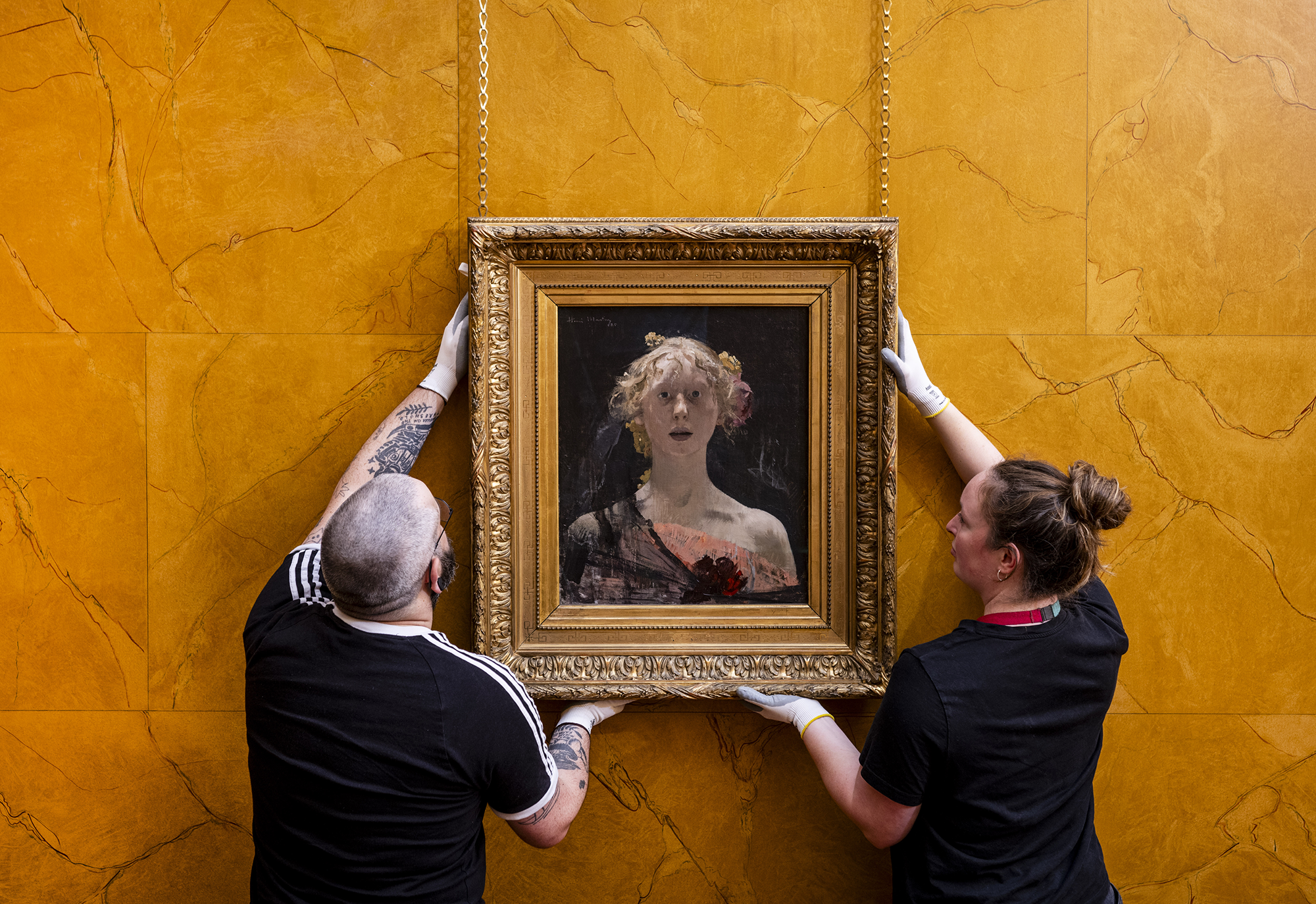 Two members of staff hang up the photo of 'Berenice'