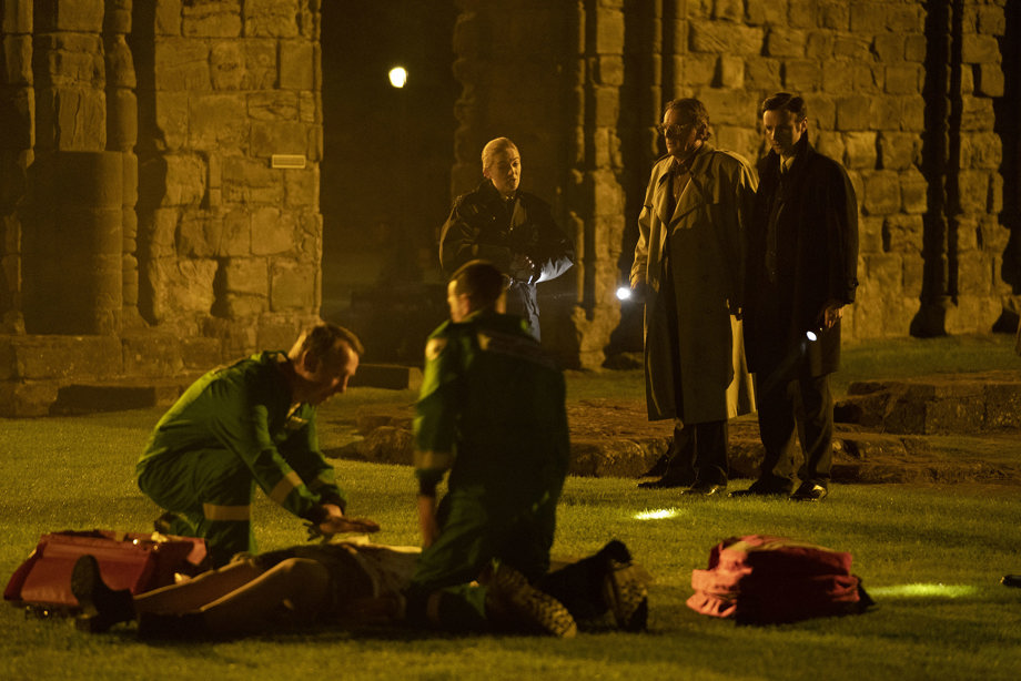 Paramedics trying to resuscitate a person with 3 police officers looking on