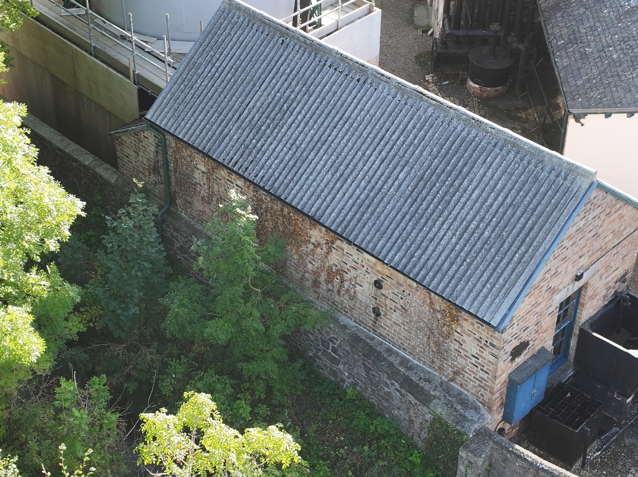 Historic industrial building with greenery to the side.