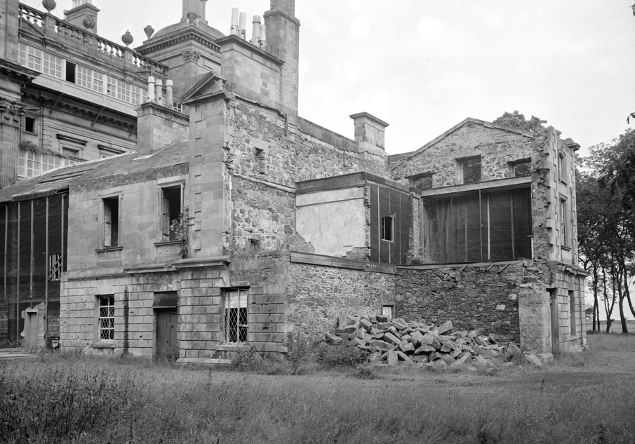 A black and white photograph showing a half demolished stately building