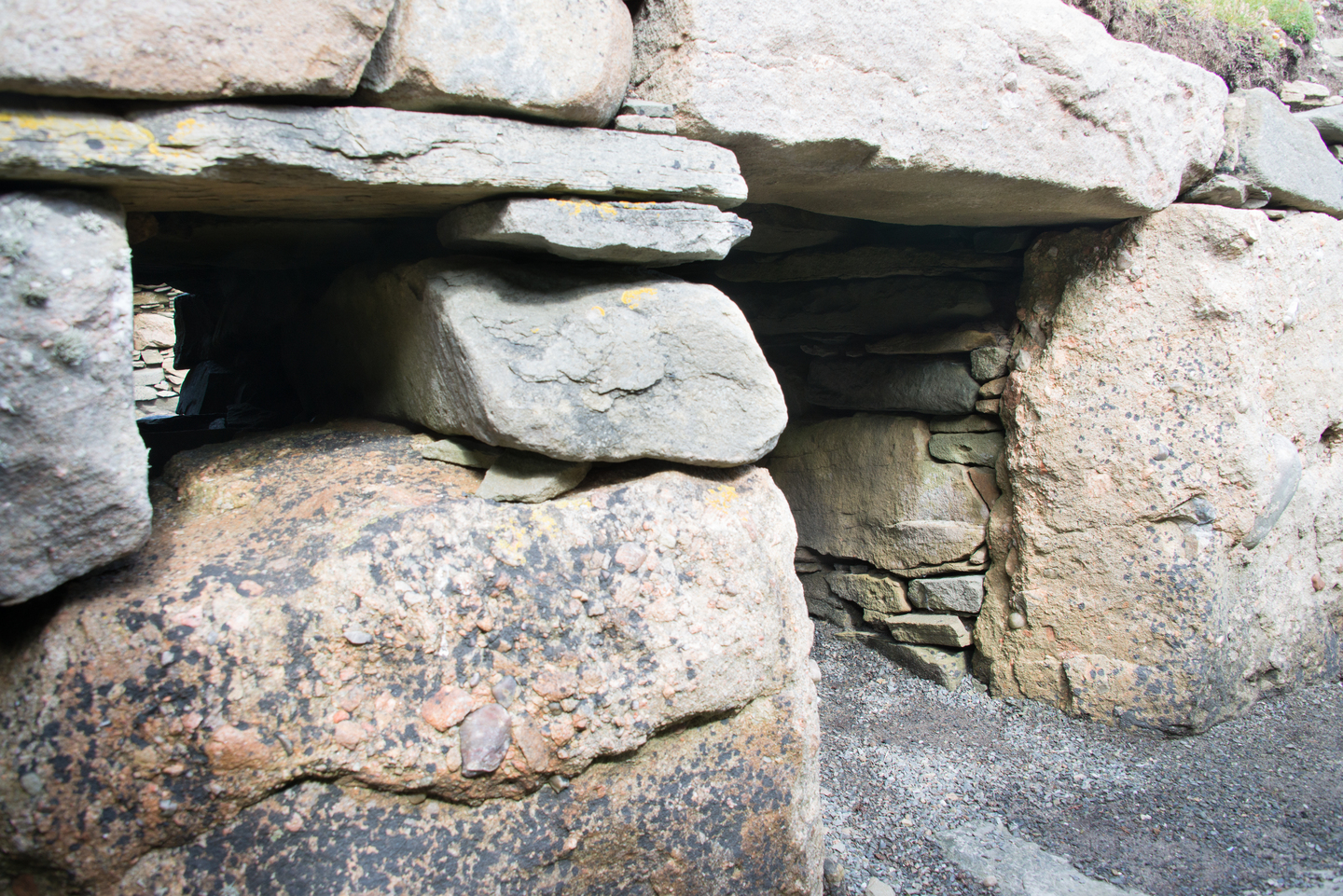 A stone entrance, with gravel on the floor.
