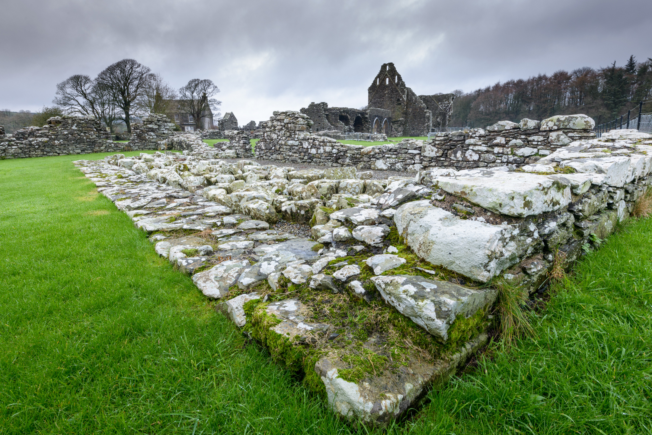 Ruins of an old building with low walls in the foreground and some higher walls remaining further away