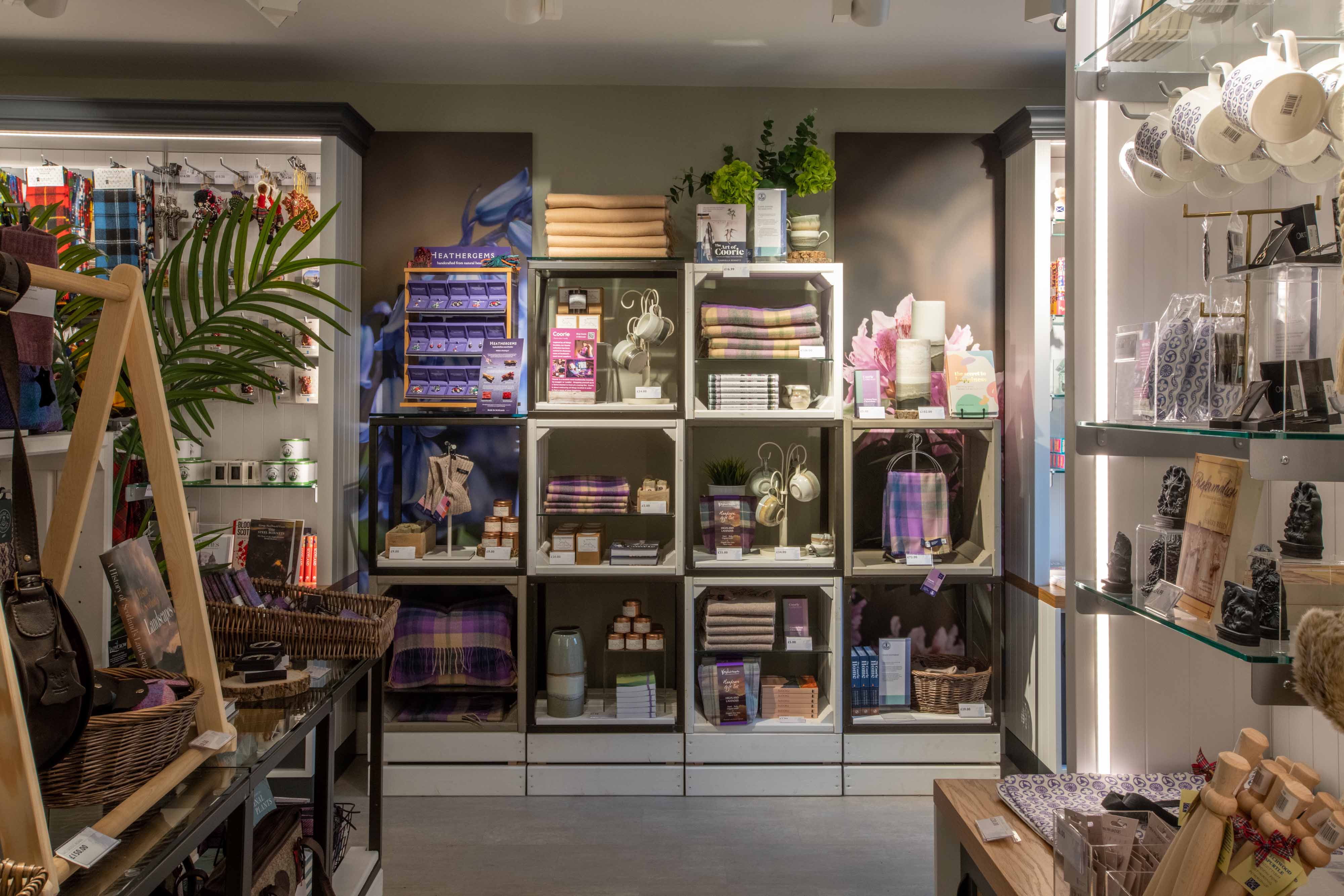 Modular shelving lining a wall, stocked full of products including scarves and candles