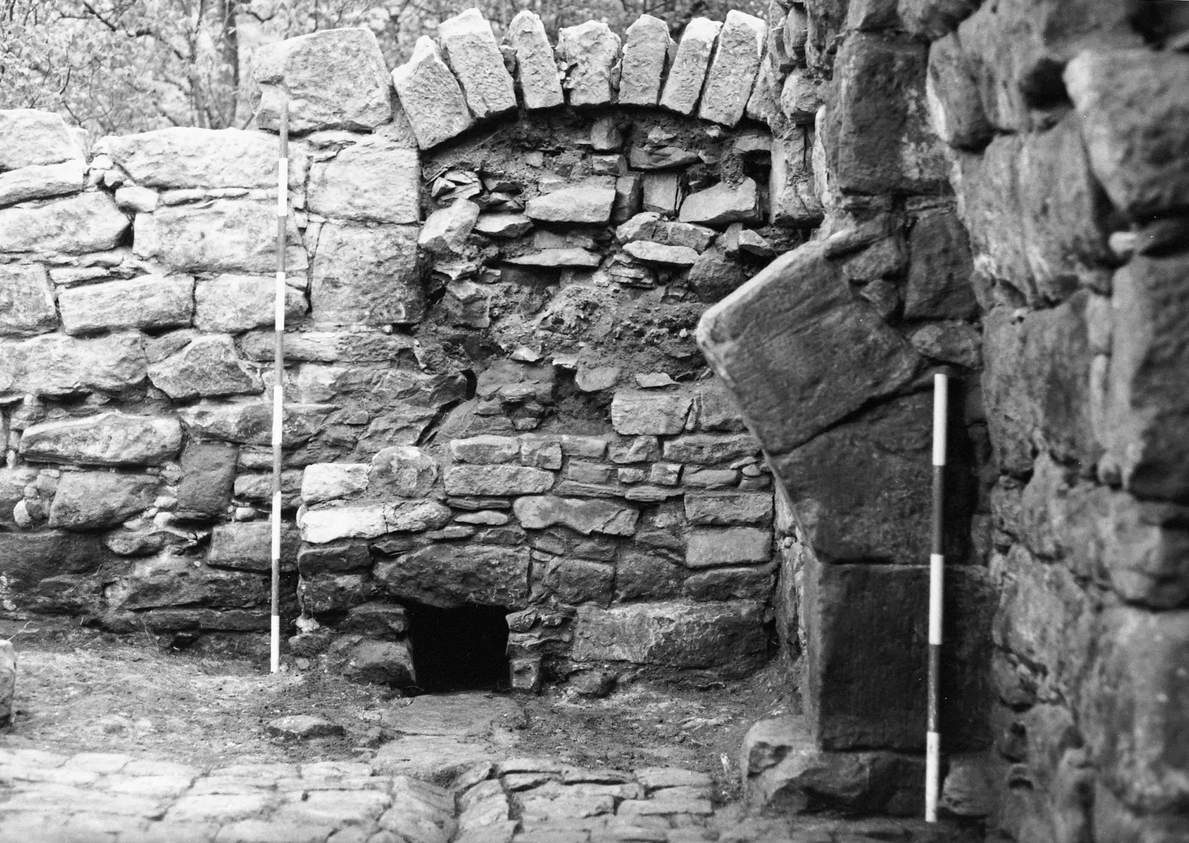 Inside a historic castle, with stone walls and a mantlepiece 