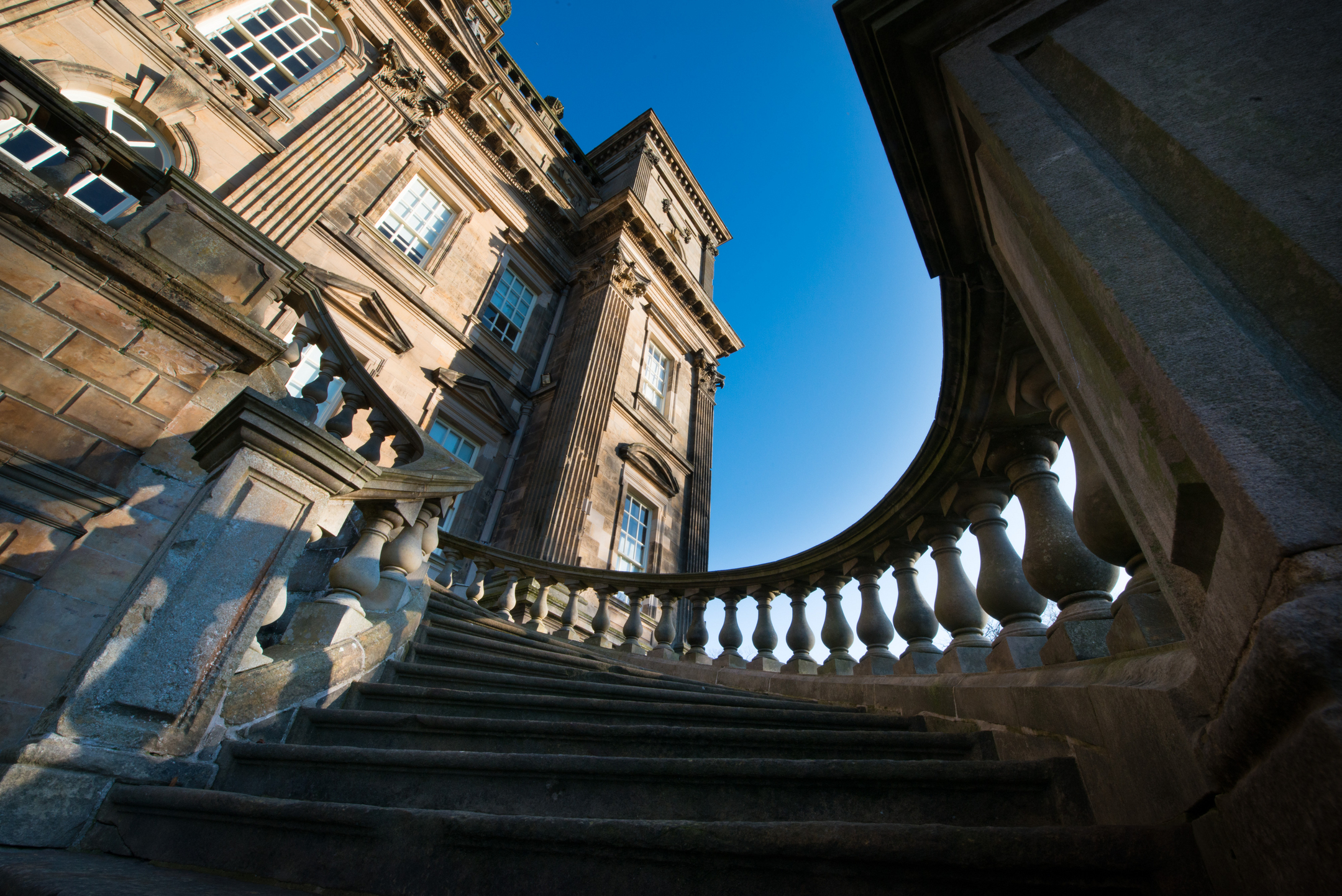 Fish eye view of the stairs at Duff House with the blue sky in the background
