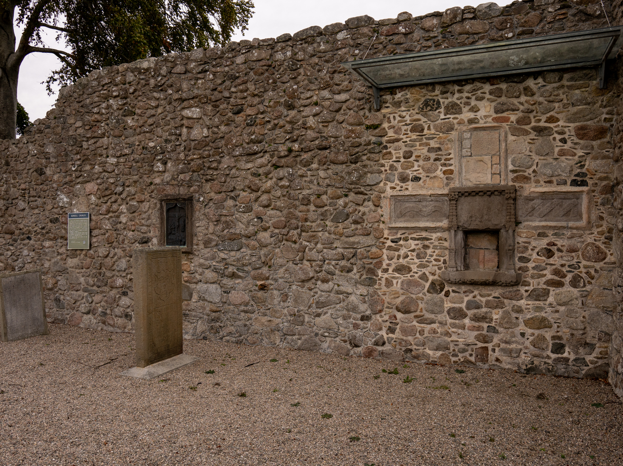 Interior side of Kinkell Church ruin showing stone walls and carved sacrament house features.
