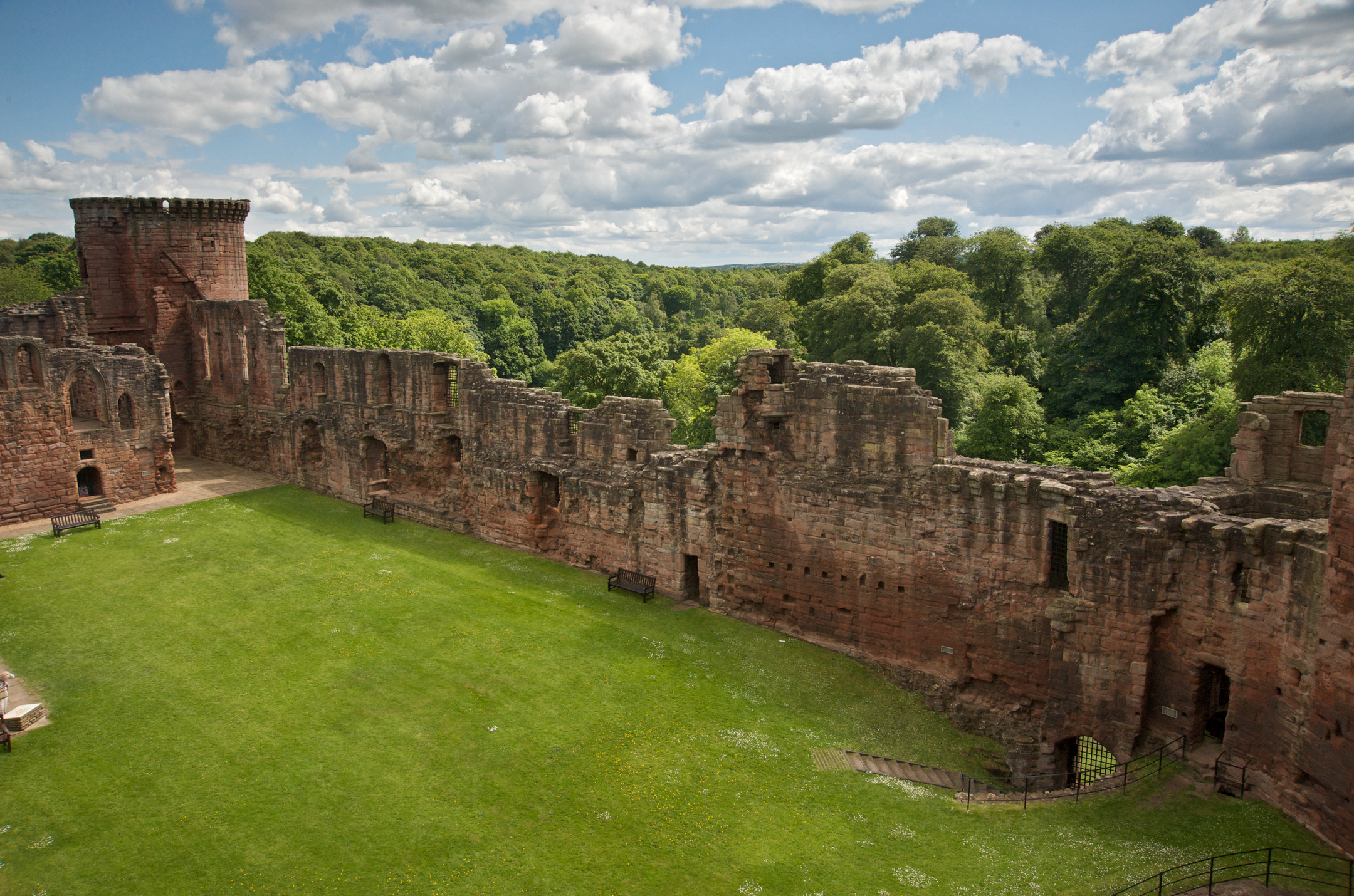 View over a curtain wall Bothwell Castle showing the green grass and cloudy sky