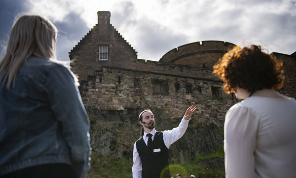 An Edinburgh Castle guide wearing a headset giving a guided tour 