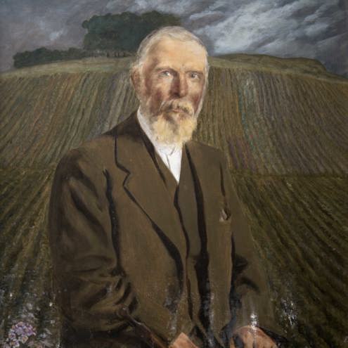 Portrait painting of older, bearded gentleman sat down in front of a ploughed field. He is wearing a brown three piece suit, with a matching flat cap by his side.