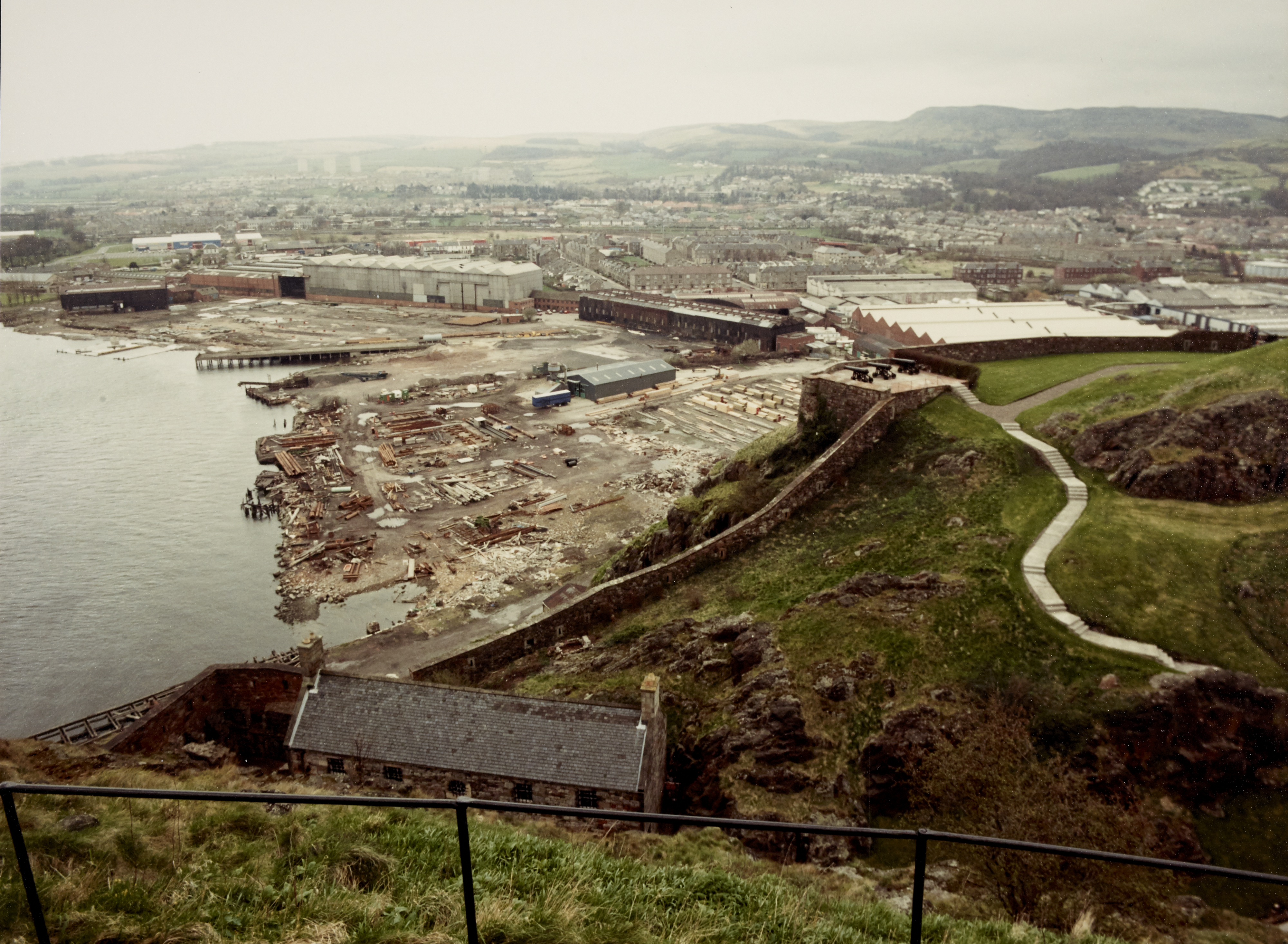 View from top of Dumbarton Castle over the castle walls and beyond to a shipping area